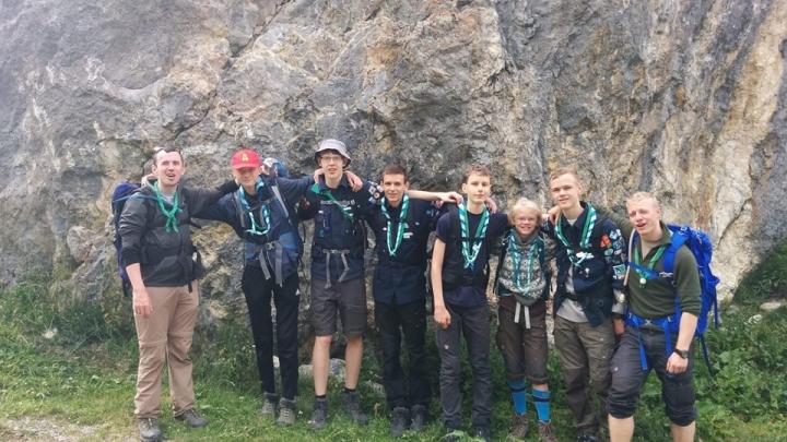Gruppebillede med oppakning foran klippe fra hejk på sommerlejren 2019 i Kandersteg